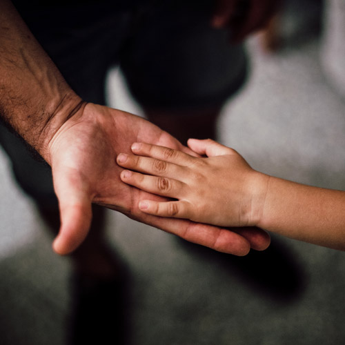 a man supporting a child's hand