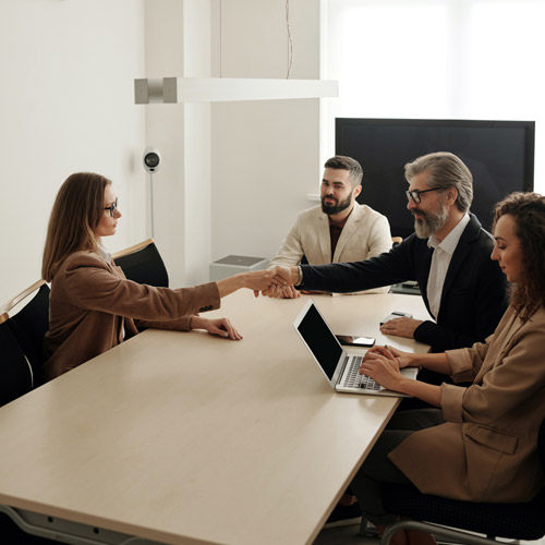 People shake hands in a meeting room