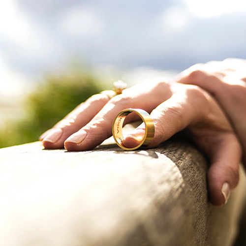 a hand holds a wedding band