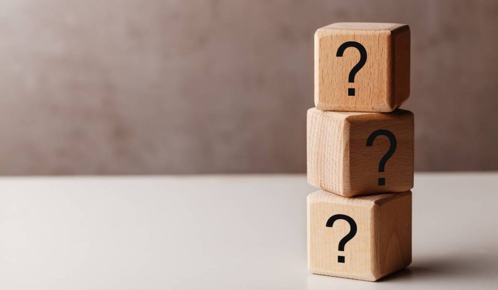 A stack of wooden blocks with question marks on them.