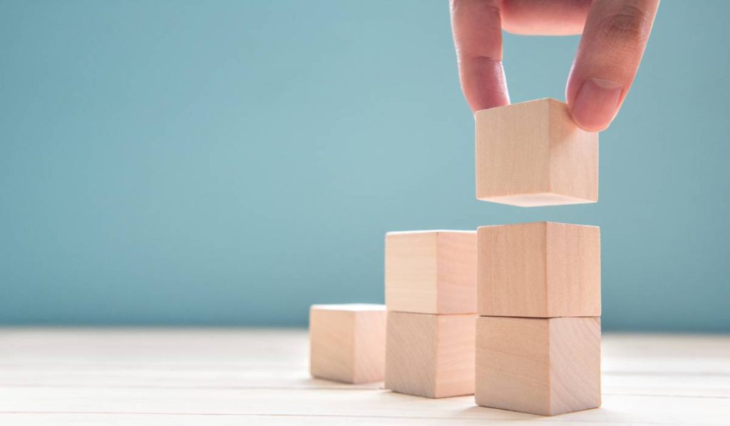 a person is stacking wooden blocks on top of each other