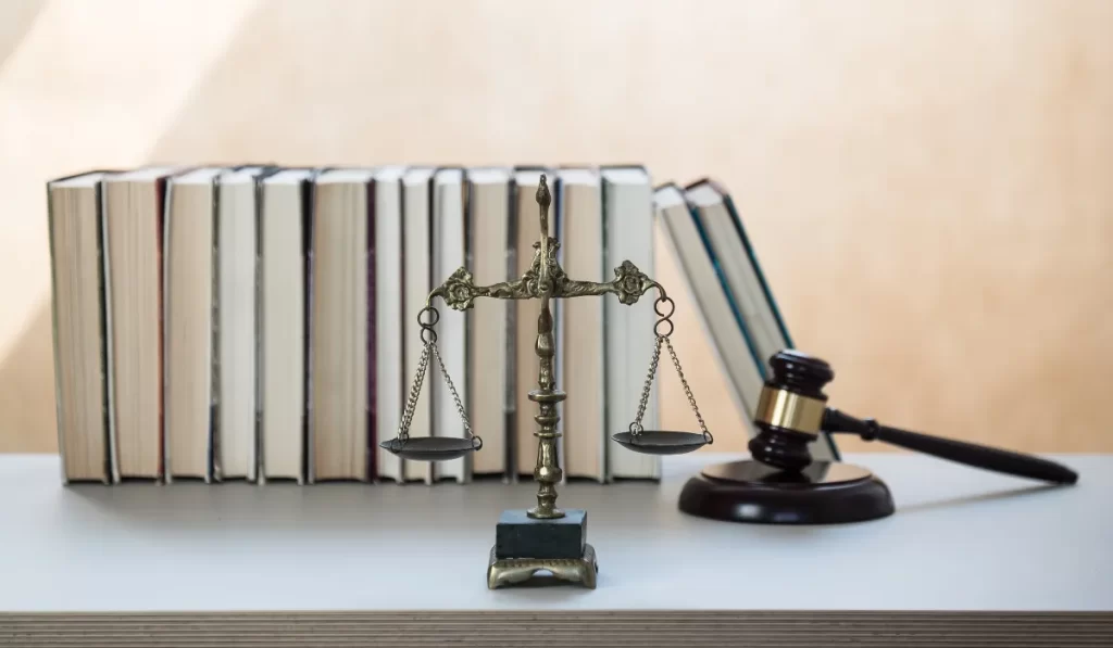Law books, balance scale of justice, and a gavel